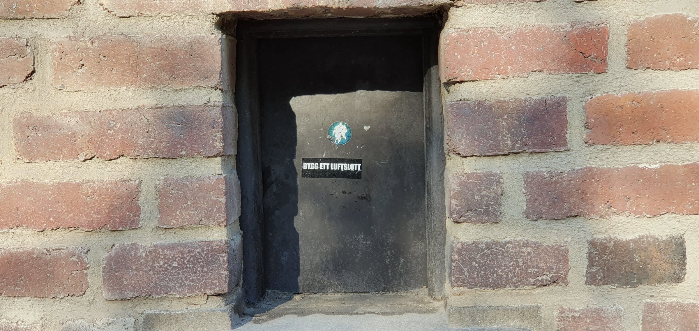 Murparti med inmurat klistermärke, Riddarholmen, Stockholm
